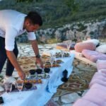 a man standing over a table filled with food